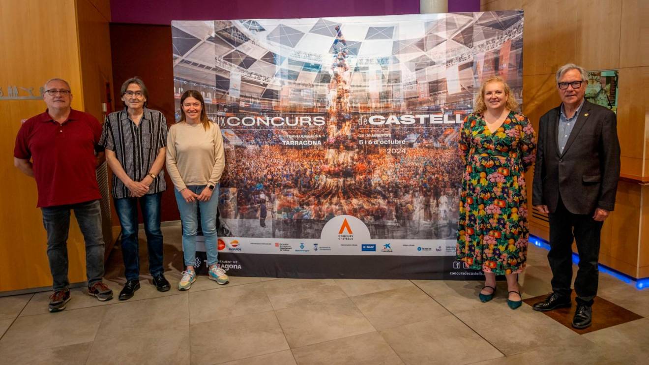 Impulsores del Concurs de Castells junto a la imagen oficial del certamen. Foto: Cedida