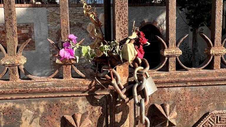 $!Mans anònimes han deixat unes flors acompanyant el cadenat de la porta de ferro del petit cementiri.
