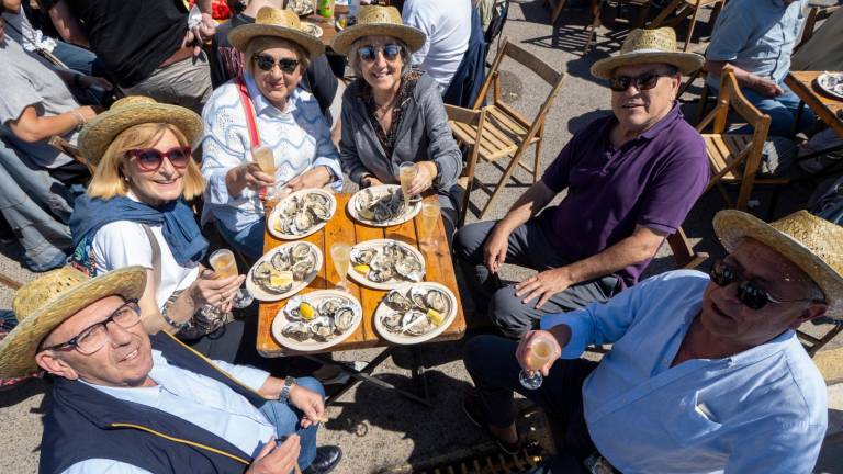 Un grup d’amics somriuen a càmera abans de començar a degustar les ostres. Foto: J. Revillas