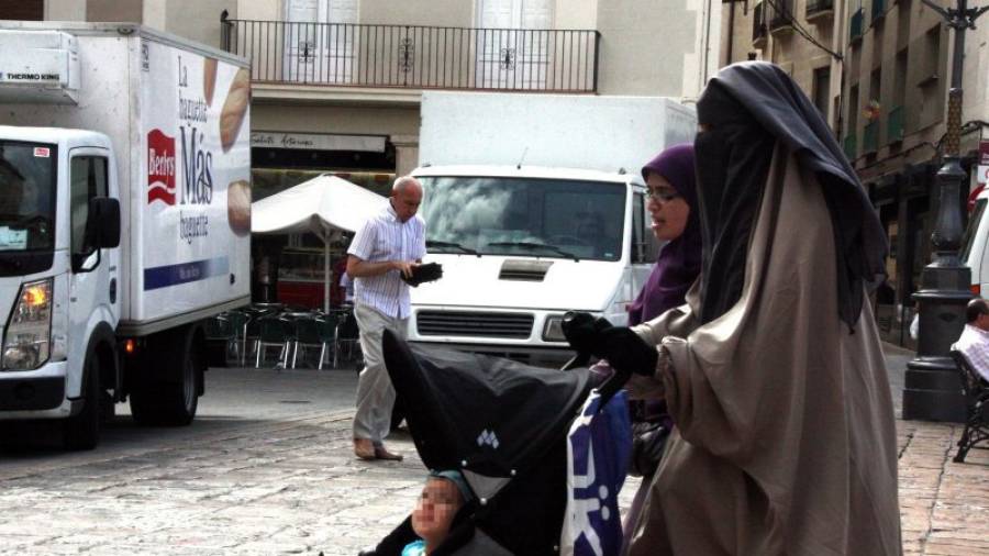 Imagen de una mujer con burka, paseando por la plaza Mercadal. Foto: DT