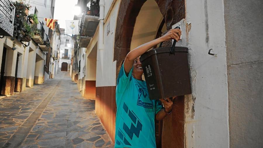 Una vecina de Riudecanyes, colocando el cubo de la basura en la puerta de su casa para la recogida ‘porta a porta’. FOTO: ALBA MARINÉFUENTE: AGÈNCIA DE RESIDUS DE CATALUNYA*MUNICIPIOS DONDE YA SE HACE EL ‘PORTA A PORTA’