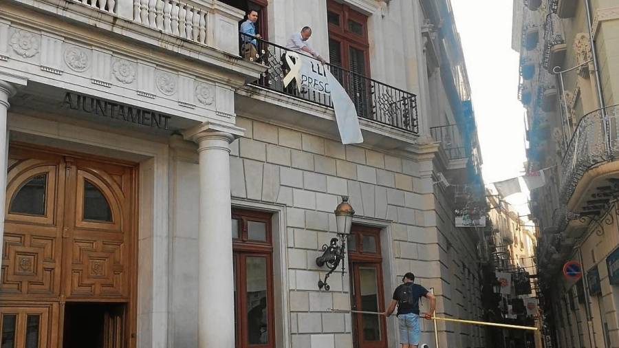 Imagen que recoge el momento en que el alcalde volvió a colgar la pancarta. FOTO: cedida