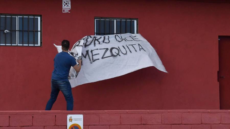 Un joven marroquí arrancó la pancarta que habían colgado algunos vecinos por la mañana en la calle Miquel Servet. FOTO: Alfredo González