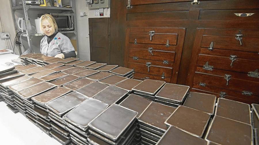 Las tabletas de chocolate se sacan del molde y se envuelven con papel, una a una, manualmente. FOTO: Joan Revillas