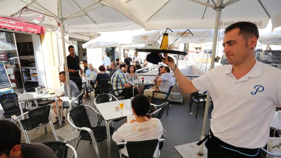 Un camarero atiende la terraza de un bar en la ciudad de Tarragona. Foto: Pere Ferré