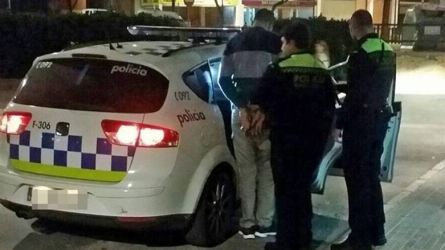 Dos agentes de la Guàrdia Urbana introduciendo un detenido por trapicheo de droga en la calle. Foto: María Ortega