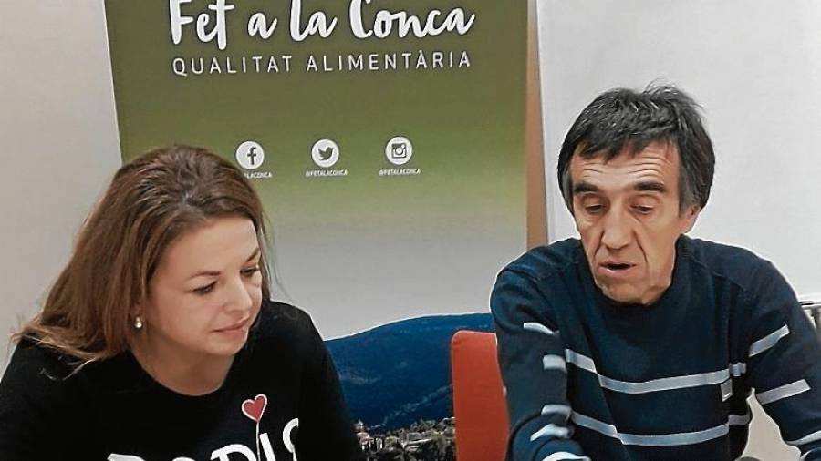 El president de Fet a la Conca, Joan Cartanyà, i la sòcia Natàlia Rodríguez comenten el material de difusió de la cooperativa. FOTO: j. b.