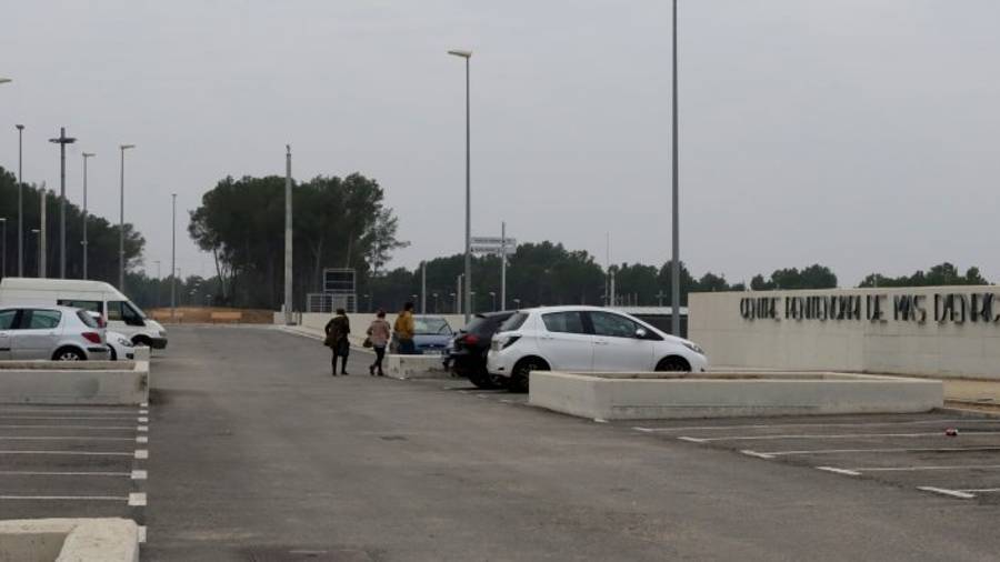 Una familia que acaba de aparcar su vehículo en el parking de la prisión y se dirige a las instalaciones para visitar a un recluso. FOTO: LLUÍS MILIÁN