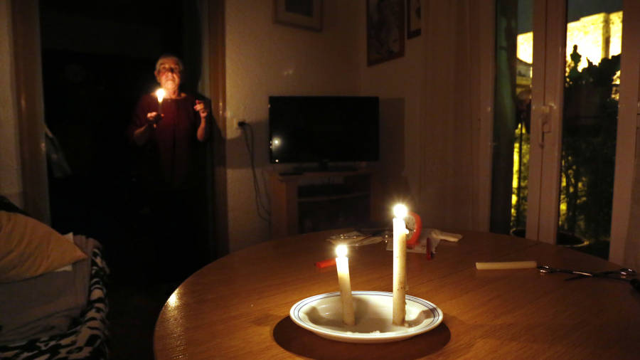Algunos vecinos todavía recurren a velas, ya no para alumbrase, sino para ‘calentar’ el aire, como esta señora. FOTO: PERE FERRÉ