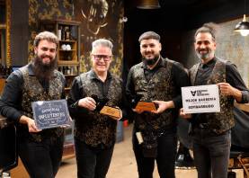 Javi Torrente, junto al equipo de su barbería, posa con los trofeos que le acreditaron en el certamen ‘Soy Barbudo’. foto: alba mariné