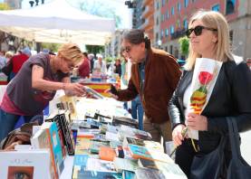 Una mujer con su rosa y un hombre comprando un libro. Foto: Àngel Ullate