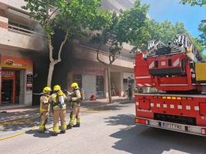 Efectivos de Bombers y humo de fondo. Foto: DT