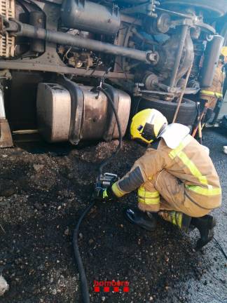 Un bombero taponando la fuga de conbustible del tráiler. Foto: Bombers de la Generalitat