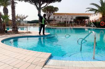 Un treballador netejant la piscina del càmping Les Medes de l’Estartit. Foto: ACN / Aleix Freixas / Xavier Pi