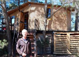 Thierry Martinet con la cabaña del árbol de Cal Galeno, un alojamiento turístico 100% autosuficiente. Foto: Roser Urgell