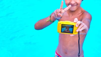 Un niño se hace un selfie dentro del agua, en una piscina foto: getty images