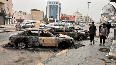 Se ven coches dañados en la calle tras los enfrentamientos en Trípoli. Foto: EFE/EPA/STRINGER