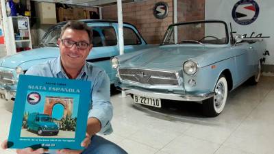 Jaume Cabot, con su libro sobre la fábrica tarraconense de coches, en el garaje de su domicilio con dos de los modelos Siata que posee. FOTO: JAUME CABOT