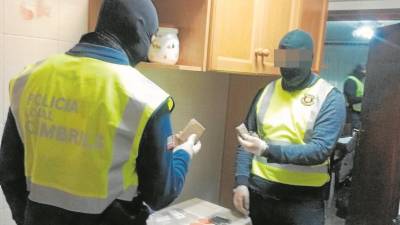 Dos agentes, uno de la Policía Local y otro de Mossos, comprueban la droga incautada. FOTO: MOSSOS D´ESQUADRA