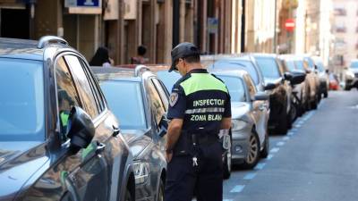 Un inspector de la zona regulada, ayer al mediodía, en el centro de Tarragona controlando los tickets de aparcamiento. foto: Pere Ferré