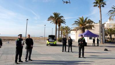 Unos agentes de la Policía Local observan el dron, en el momento de elevarse. foto: Pere Ferré