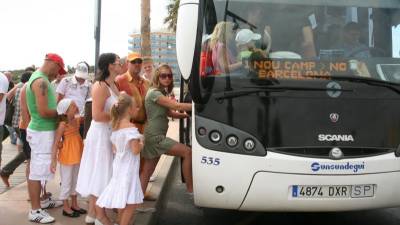 Imatge d'arxiu d'un grup de turistes a La Pineda agafant un autobús per anar al Camp Nou a Barcelona. Foto: ACN