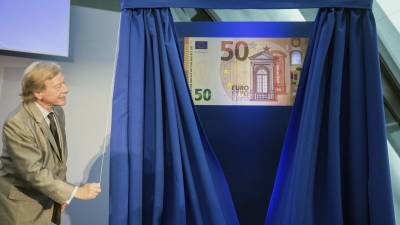 El miembro luxemburgués del comité ejecutivo del Banco Central Europeo (BCE) Yves Mersch posa junto a una fotografía ampliada del nuevo billete de 50 euros presentado en la sede del BCE en Fráncfort, Alemania. EFE/Frank Rumpenh