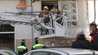 Momento en que los bomberos accedían a la ventana de las oficinas para sacar al detenido. Foto: Lluís Milián