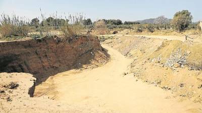 En unos terrenos cercanos a la riera de Alforja, hay un agujero donde camiones descargan escombros. FOTO: DT