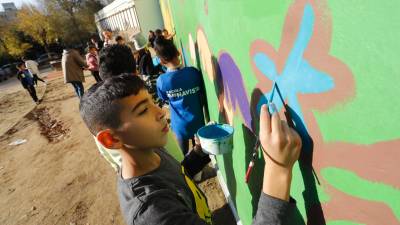 Alumnos de escuelas del barrio han ayudado a pintar la parte baja del mural. Foto: Pere Ferré