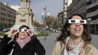 Dues noies contemplen l'eclipsi a Tarragona amb ulleres especials. Foto: Pere Ferré