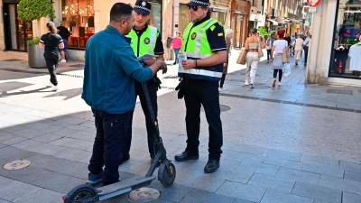 Una pareja de policías, en la plaza Prim, distribuyendo folletos entre los usuarios del patinete. Foto: Alfredo González