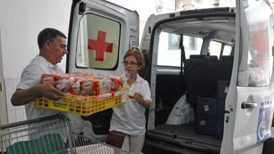 El coordinador de ´Menjar a domicili´, Joan Aragonés carga la furgoneta de Cruz Roja para realizar el reparto. Foto: Alfredo González