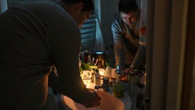 Andrei Agaci lavándose las manos iluminado por dos velas. El bloque de pisos dónde vive no tiene luz desde hace diez días. FOTO: A. GONZÁLEZ
