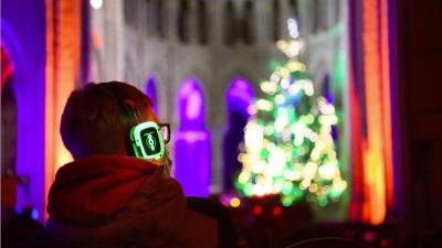 Usando mascarillas y escuchando con audífonos la meditación, las historias y las canciones en la víspera de Navidad durante el evento 'La noche silenciosa, Navidad en los oídos', en la Catedral de Lausana, Suiza.&nbsp;EFE/EPA/LAURENT GILLIERON