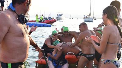Siscu, abrazado por uno de los nadadores nada más llegar a puerto,. FOTO: Alfredo Gonzáĺez