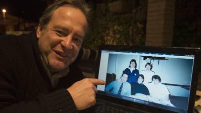 Eduardo Ruiz señala una foto suya con unas enfermeras con las que trabajó en una hospital de Escocia. Estuvo cinco años en el Reino Unido. Foto: Joan Revillas