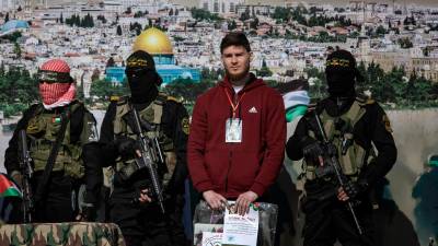Militantes de Hamás y la Yihad Islámica están junto al rehén ruso-israelí Sasha (Alexander) Troufanov antes de entregarlo al equipo de la Cruz Roja, en Khan Yunis, en el sur de la Franja de Gaza. Foto: EFE