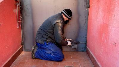 Un cerrajero tapiando la entrada exterior de una vivienda. Foto: Alfredo González