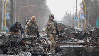 Soldados ucranianos inspeccionan material militar ruso destruido en la zona recuperada en la ciudad de Bucha. foto: EFE/EPA/ATEF SAFADI