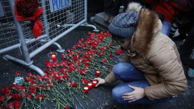 La gente pone flores y velas en una valla policial en frente de la discoteca Reina después de un ataque de armas. Foto: EFE