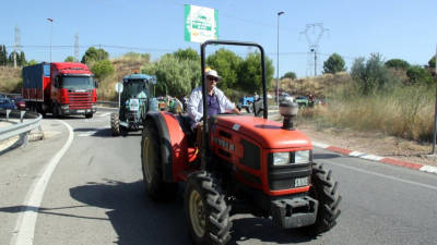 Pla sencer d'un pagès al damunt del tractor protestant abans d'accedir a la T-11 a l'alçada de Reus el 13 d'agost del 2016.