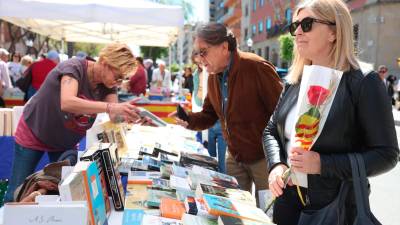 Una mujer con su rosa y un hombre comprando un libro. Foto: Àngel Ullate