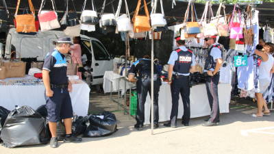 Un agente custodia las bolsas con el material confiscado, mientras sus compa&ntilde;eros levantan acta. Foto: Alba Marin&eacute;