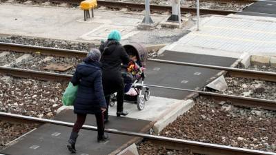 Imagen de ayer por la mañana de una familia cruzando las vías del tren para acceder a un andén de la estación tarraconense. Foto: Lluís Milián