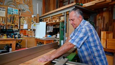 Un artesano ebanista trabajando un listón de madera en su taller, ubicado en Reus. Foto: Alfredo González