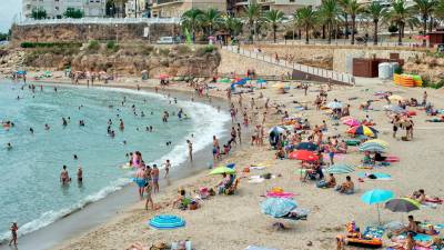 Turistas en la playa de l’Alguer, en
