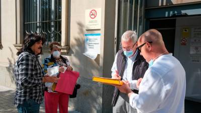 Josep Tutusaus y Josep Ramon Pallejà, ayer, reuniendo apoyos de pacientes, ante al CAP. Foto: Fabián Acidres