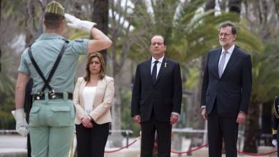 Los presidentes de los Gobiernos de España, Mariano Rajoy, y Francia, François Hollande, acompañados de la presidenta de la Junta de Andalucía, Susana Díaz, escuchan los respectivos himnos a su llegada este lunes a la XX