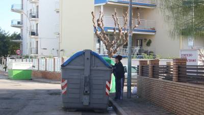 Una vecina deposita la basura (en este caso papel y cartón) en un contenedor de la calle Lleida. FOTO: A. MARINÉ